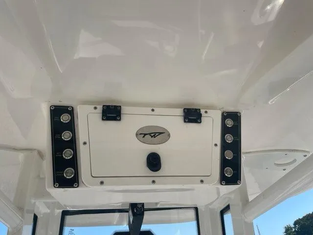 Slide: The Image of 2023 Tidewater 232 SS boat console with control panel and storage compartment. - 2
