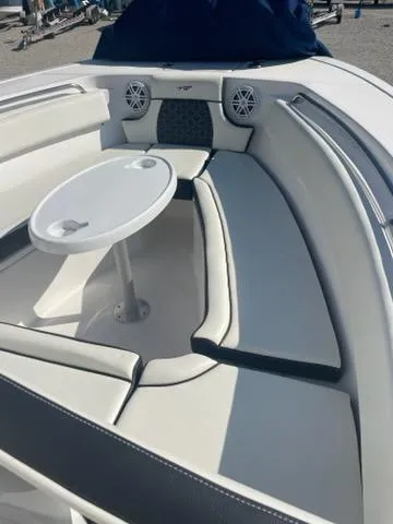 Slide: The Image of 2023 Tidewater 232 SS boat interior with cushioned seating and round table. - 3