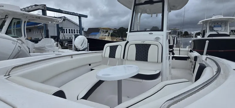 Slide: The Image of 2023 Tidewater 232 SS boat interior with seating and table, docked at marina. - 8