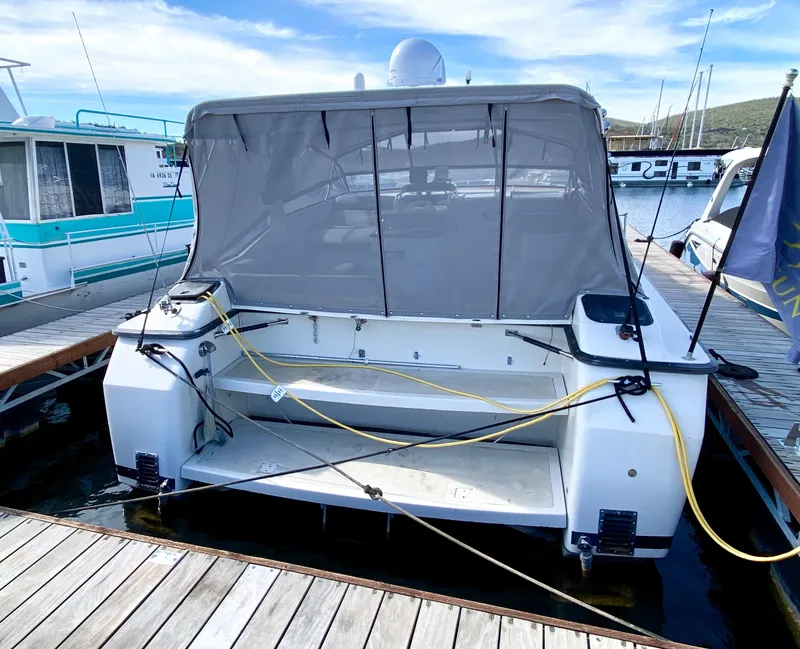 Slide: The Image of 1989 Mainship 39 Mediterranean Express docked at marina, rear view with canopy. - 14