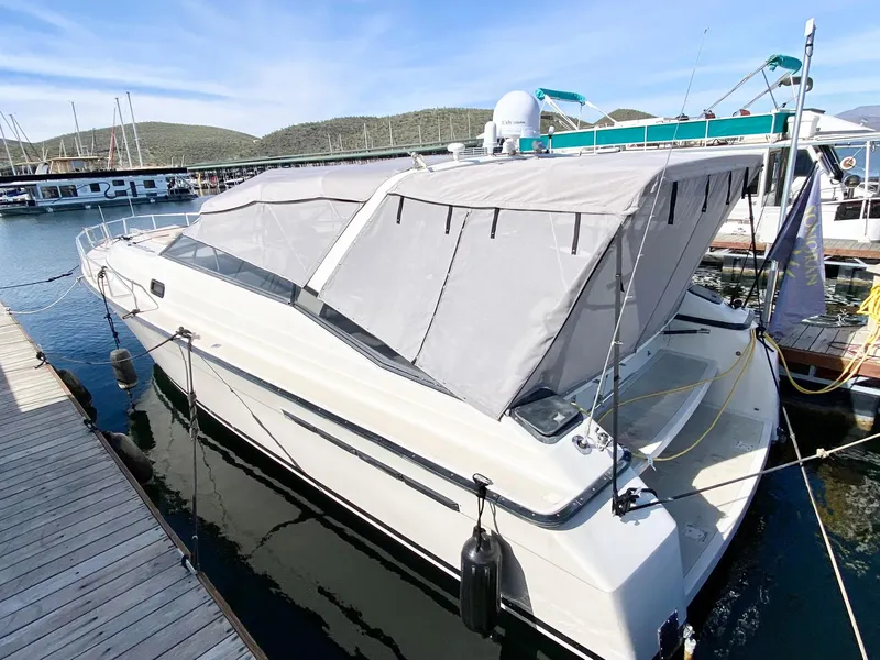 Slide: The Image of 1989 Mainship 39 Mediterranean Express docked at marina with protective canopy. - 25