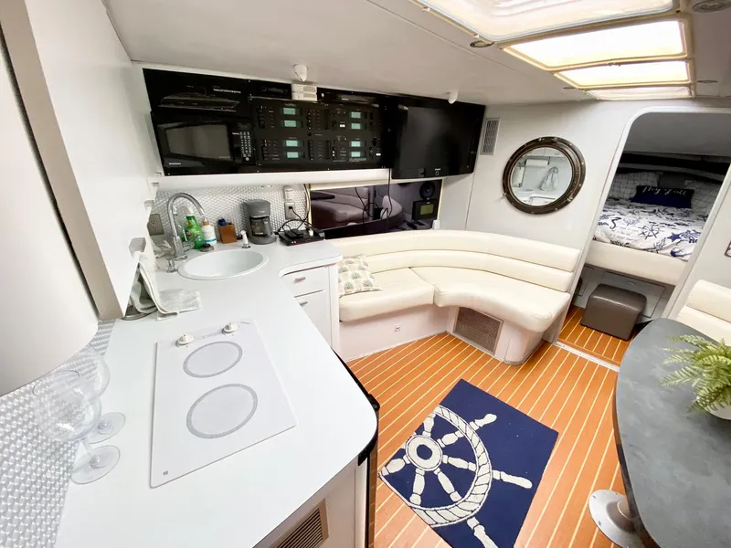 Slide: The Image of 1989 Mainship 39 Mediterranean Express interior with modern kitchen, seating, and nautical decor. - 5