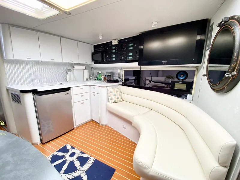 Slide: The Image of 1989 Mainship 39 Mediterranean Express interior with kitchenette, curved seating, and modern amenities. - 6