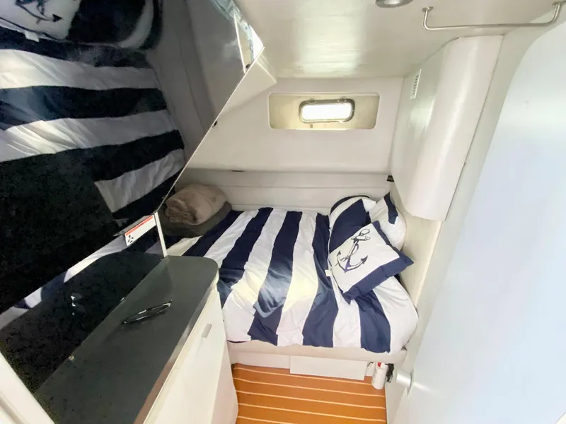 Slide: The Image of Cozy cabin interior of 1989 Mainship 39 Mediterranean Express with striped bedding. - 8