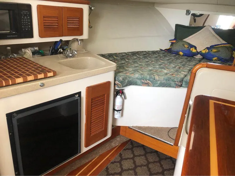 Slide: The Image of Interior of 2001 Pursuit 3000 Express boat with kitchenette and cozy sleeping area. - 12
