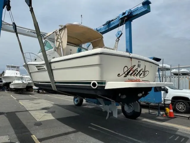 Slide: The Image of 2001 Pursuit 3000 Express boat being lifted at a marina. - 3