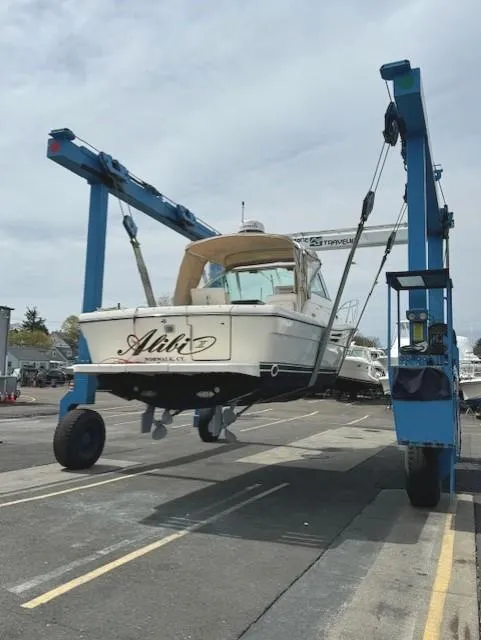 Slide: The Image of 2001 Pursuit 3000 Express boat lifted by crane in a marina. - 5