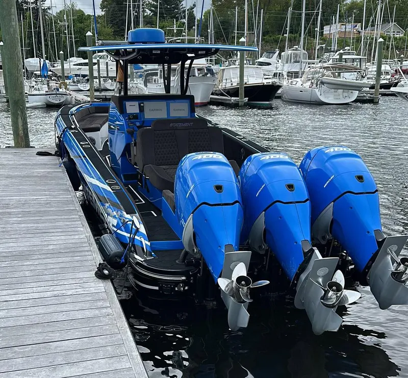 Slide: The Image of 2021 Statement 380 Open boat with triple blue outboard engines docked at marina. - 20