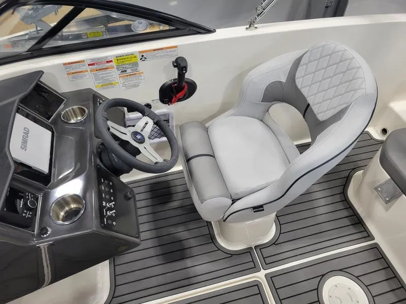 Slide: The Image of 2025 Bayliner VR5 OB boat interior with steering wheel and cushioned seat. - 12