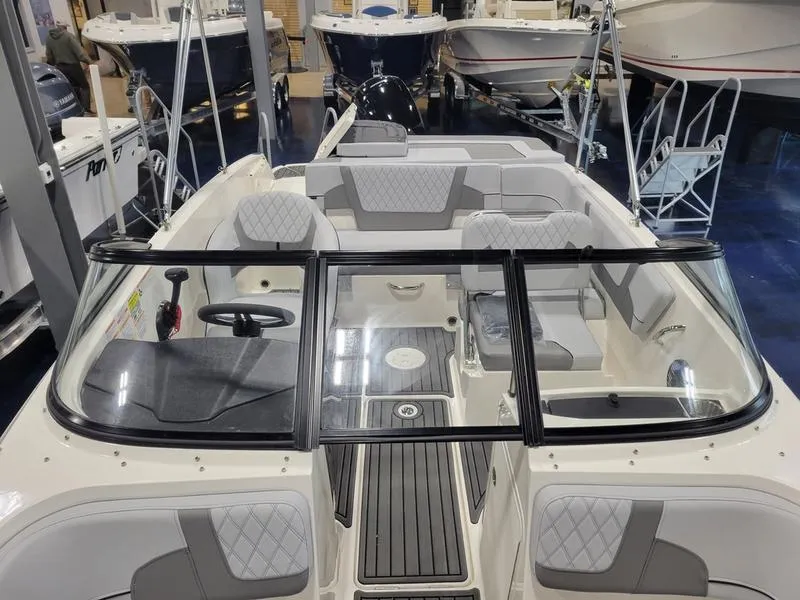 Slide: The Image of 2025 Bayliner VR5 OB boat interior with seating and steering wheel in showroom. - 9