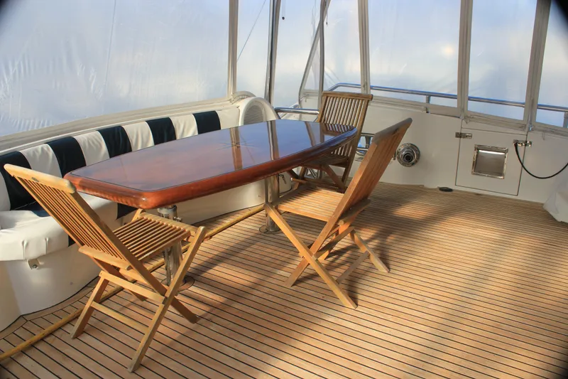 Slide: The Image of Luxurious Horizon P70 yacht deck with wooden table and chairs, 2004 model. - 2