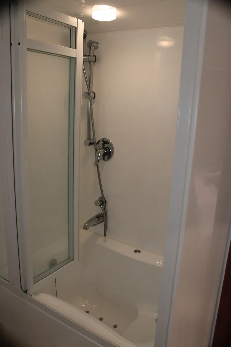 Slide: The Image of Compact shower unit in a 2004 Horizon P70, featuring glass door and modern fixtures. - 20