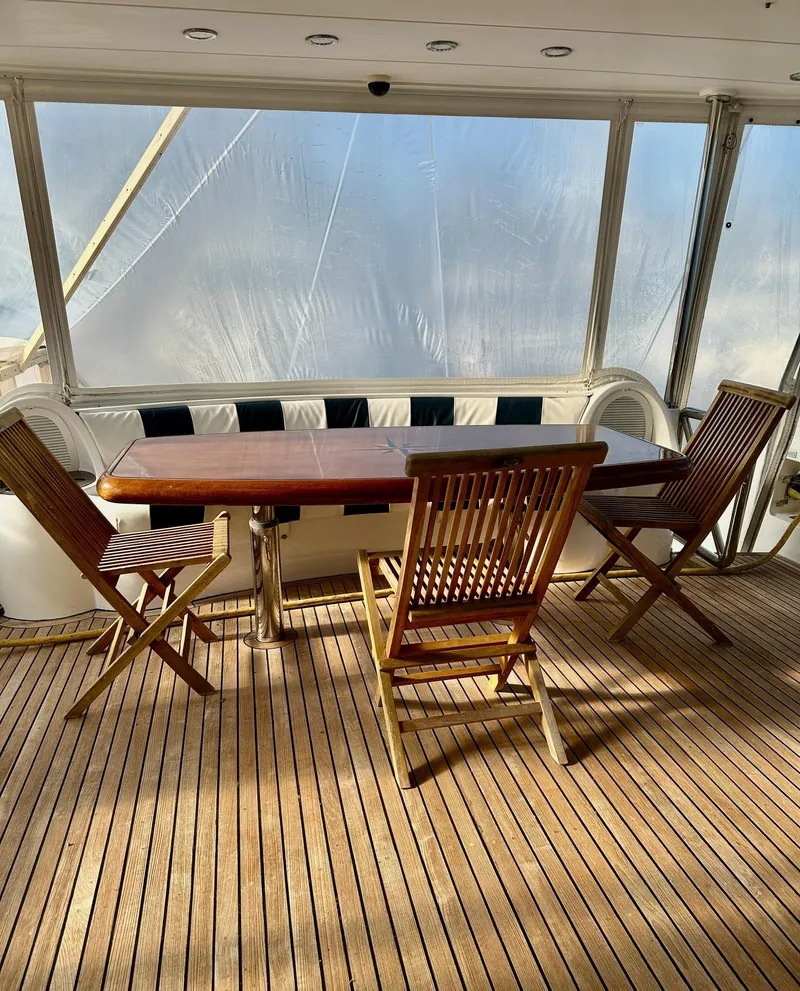 Slide: The Image of Teak deck with wooden chairs and table on 2004 Horizon P70 yacht. - 3
