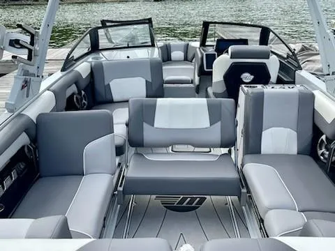 Slide: The Image of 2021 Malibu Wakesetter 25 LSV interior with gray and white seating, docked by the water. - 3