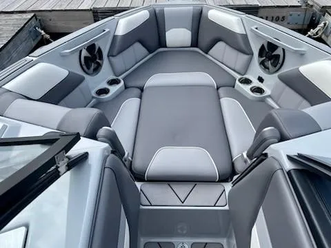 Slide: The Image of 2021 Malibu Wakesetter 25 LSV interior with gray and white seating, cup holders, and speakers. - 5