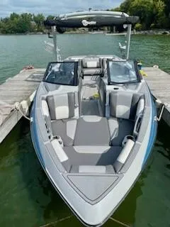 Slide: The Image of 2021 Malibu Wakesetter 25 LSV boat docked on a lake. - 6