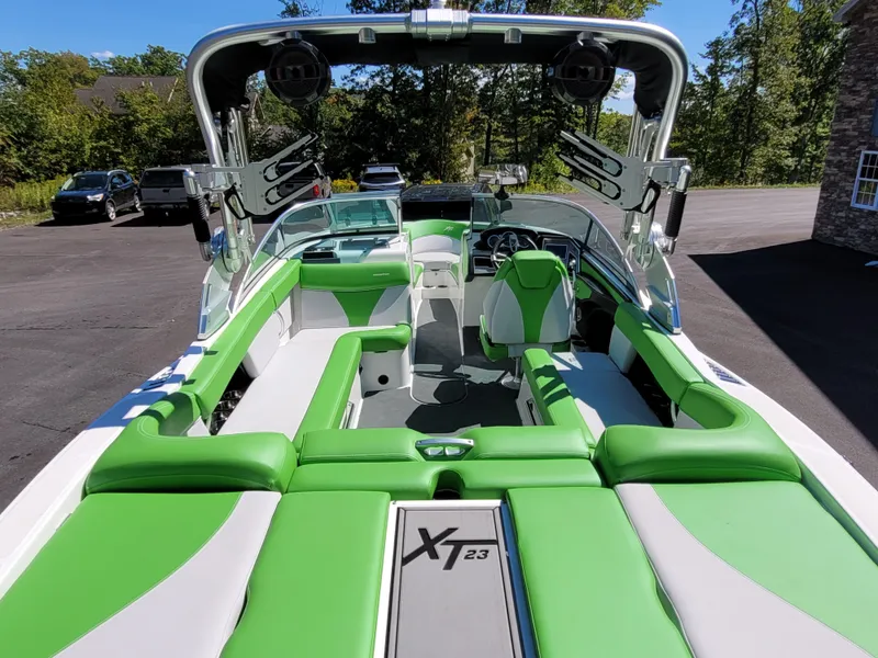 Slide: The Image of 2019 MasterCraft XT23 boat with green and white interior, parked outdoors. - 7