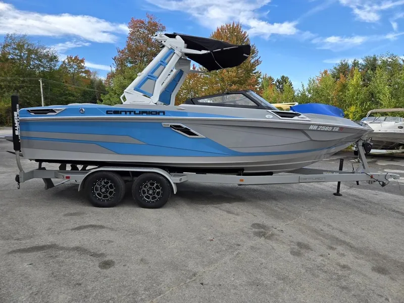 Slide: The Image of 2023 Centurion Ri230 boat on trailer, blue and gray, parked outdoors. - 1