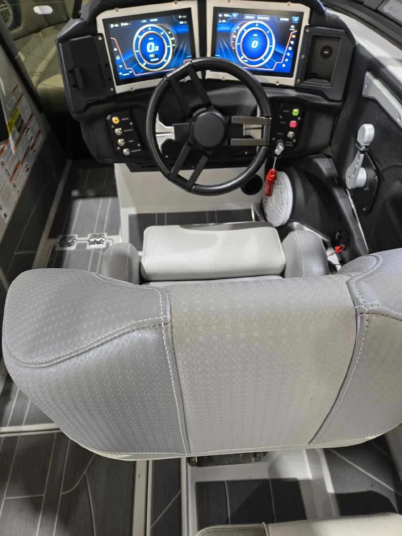 Slide: The Image of 2023 Centurion Ri230 boat cockpit with dual digital displays and modern steering wheel. - 8