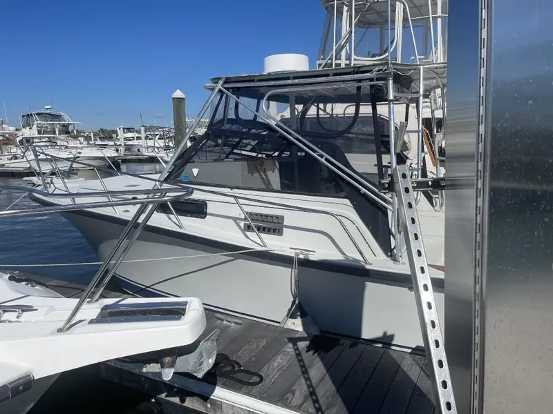 Slide: The Image of 1987 Rampage 31 Express boat docked at marina under clear blue sky. - 1