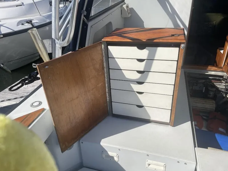 Slide: The Image of 1987 Rampage 31 Express boat interior with open wooden storage cabinet. - 10