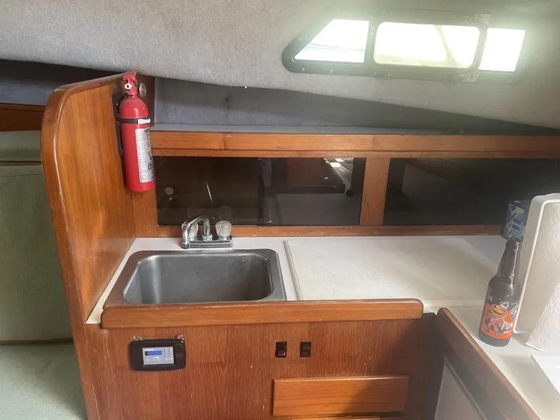 Slide: The Image of 1987 Rampage 31 Express boat interior with sink, countertop, and fire extinguisher. - 18