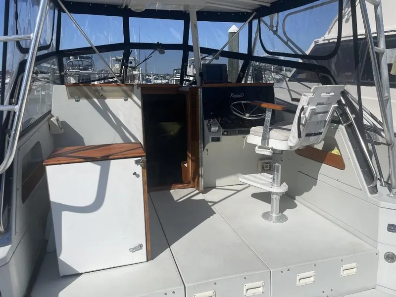 Slide: The Image of 1987 Rampage 31 Express boat cockpit with helm, seating, and storage. - 5