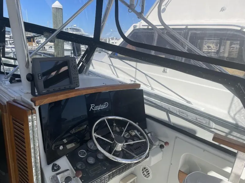 Slide: The Image of 1987 Rampage 31 Express boat helm with steering wheel and navigation equipment. - 6