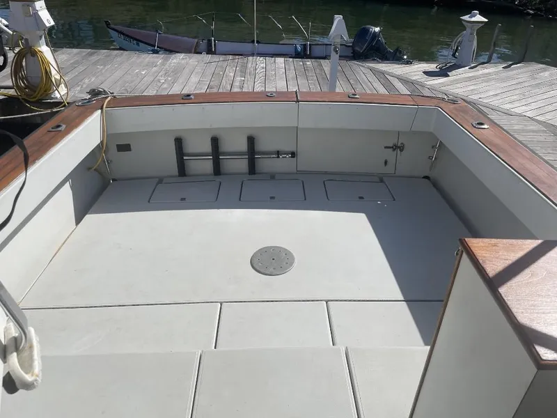 Slide: The Image of 1987 Rampage 31 Express boat deck, spacious and clean, docked by the water. - 8