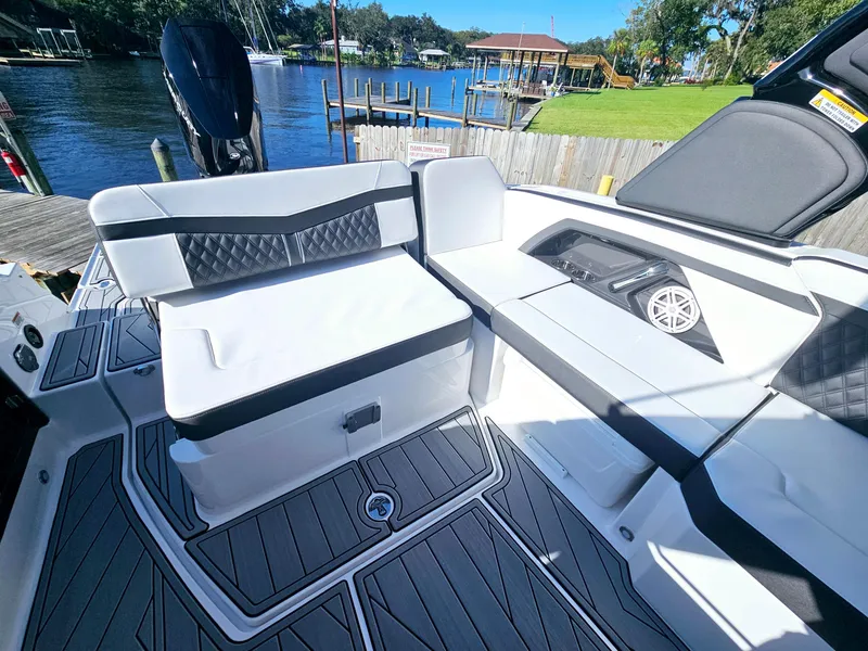 Slide: The Image of 2025 Monterey 255SS boat interior with sleek seating and modern design by the water. - 14