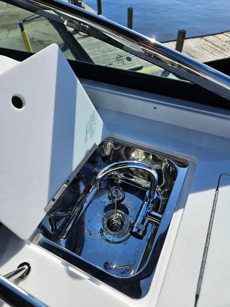 Slide: The Image of 2025 Monterey 255SS boat sink with chrome faucet, dockside view. - 17