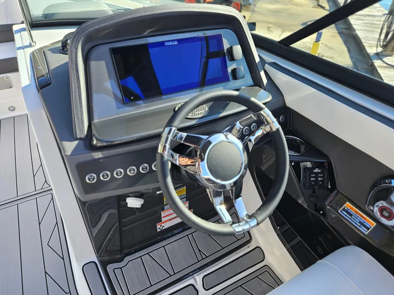 Slide: The Image of 2025 Monterey 255SS boat dashboard with modern steering wheel and digital display. - 23