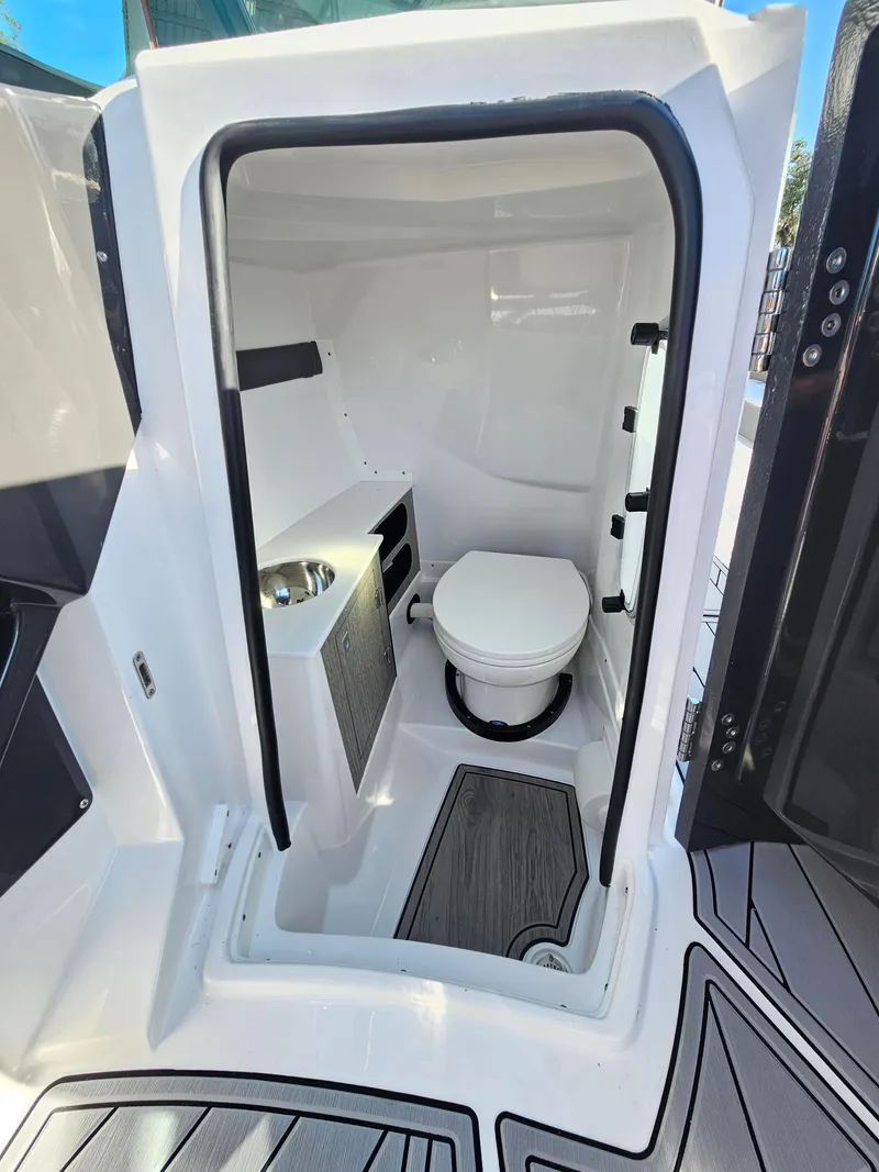 Slide: The Image of 2025 Monterey 255SS boat interior with compact bathroom and toilet. - 33