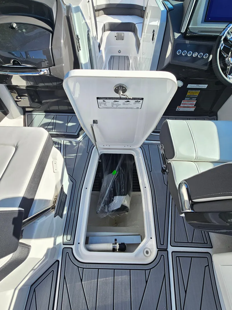 Slide: The Image of 2025 Monterey 255SS boat interior with open storage compartment and modern seating. - 34
