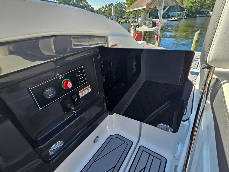 Slide: The Image of 2025 Monterey 255SS boat interior with control panel, docked by a scenic waterfront. - 35