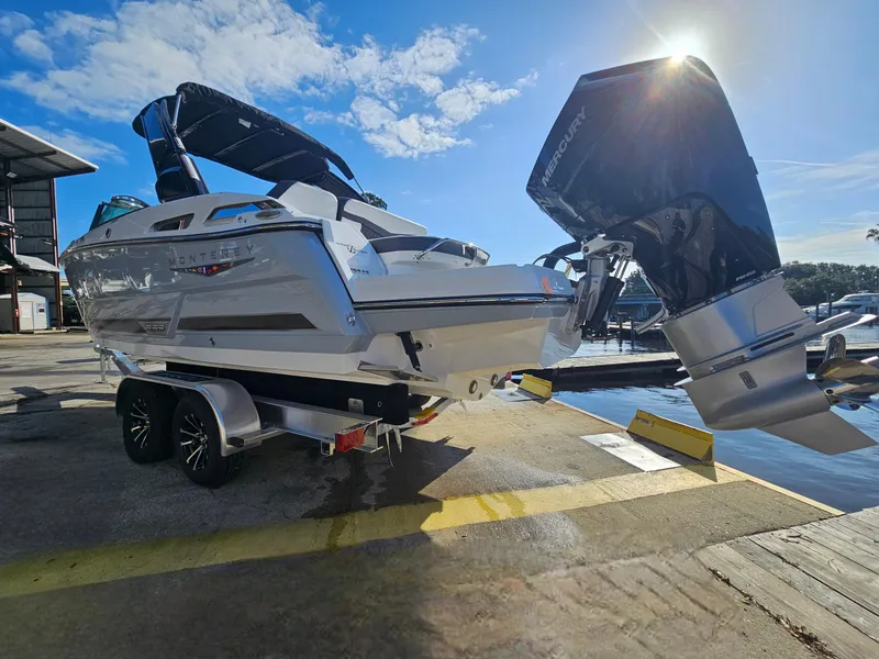Slide: The Image of 2025 Monterey 255SS boat on trailer, dockside, with outboard motor, under sunny sky. - 6