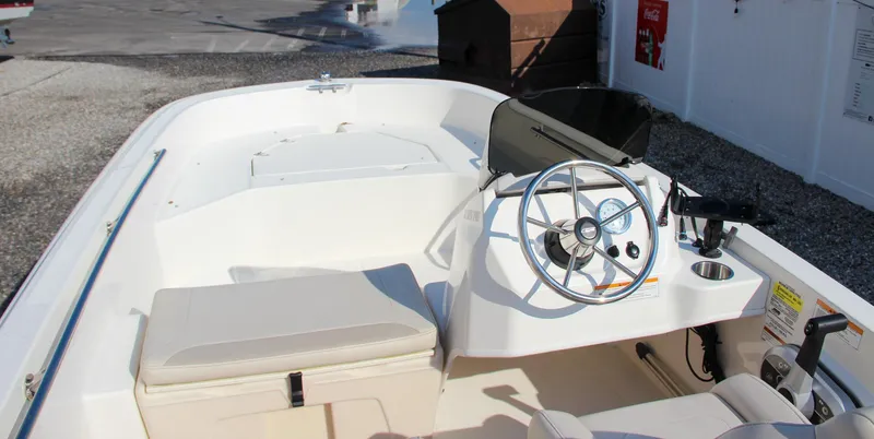Slide: The Image of 2022 Boston Whaler 160 Super Sport boat interior with steering wheel and seating. - 10