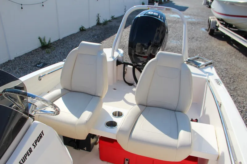 Slide: The Image of 2022 Boston Whaler 160 Super Sport boat interior with dual seats and outboard motor. - 15