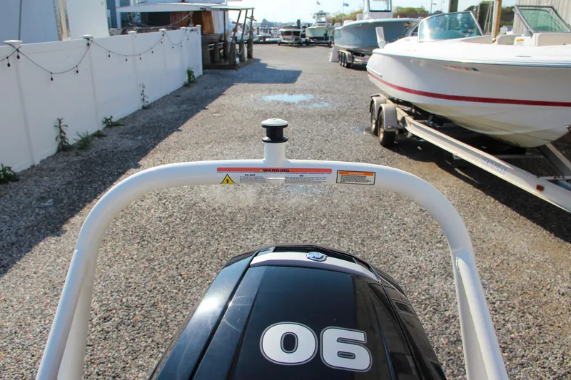 Slide: The Image of Boston Whaler 160 Super Sport 2022 on gravel lot with outboard motor. - 21