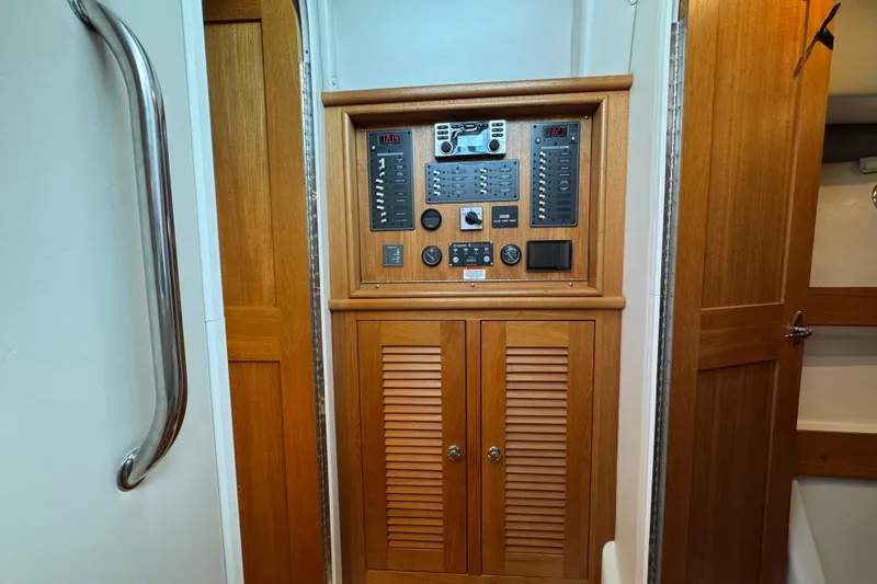Slide: The Image of Electrical panel on 2006 Glacier Bay 3470 Ocean Runner boat, featuring wooden cabinetry. - 17