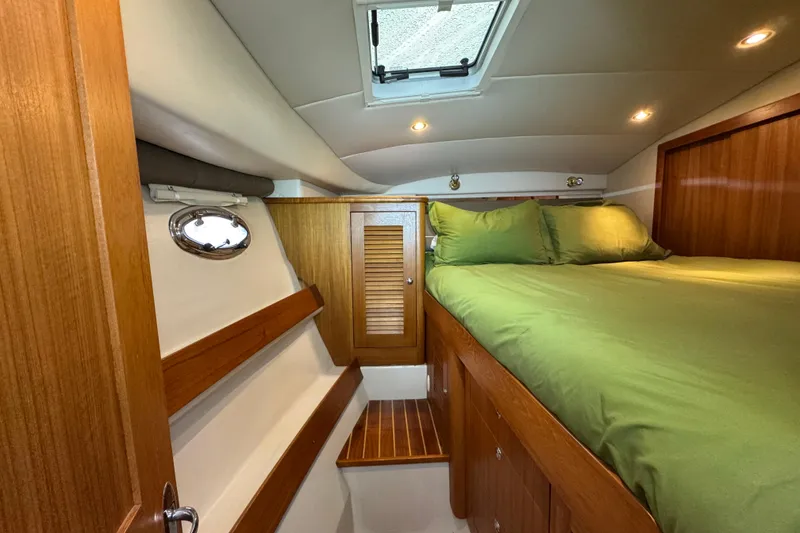 Slide: The Image of Cozy cabin interior of 2006 Glacier Bay 3470 Ocean Runner with green bedding. - 7