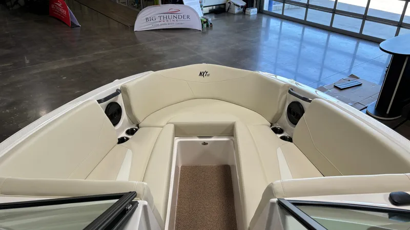 Slide: The Image of 2025 MasterCraft NXT23 boat interior with beige seating and speakers. - 13