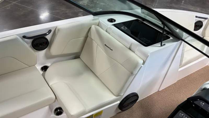 Slide: The Image of 2025 MasterCraft NXT23 boat interior with white seating and sleek design. - 24
