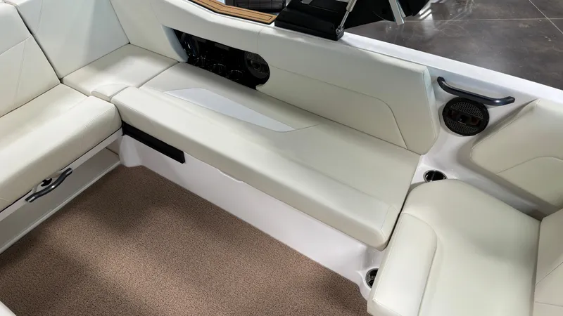 Slide: The Image of 2025 MasterCraft NXT23 boat interior with white seating and beige carpet. - 25