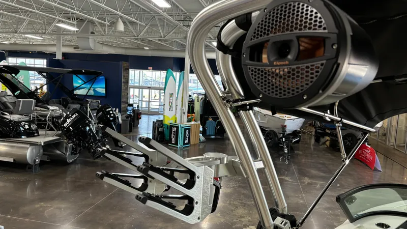 Slide: The Image of 2025 MasterCraft NXT23 boat interior with speaker and wakeboard rack in showroom. - 28