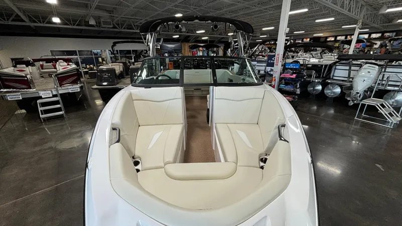 Slide: The Image of 2025 MasterCraft NXT23 boat interior in showroom, featuring sleek white seating. - 32