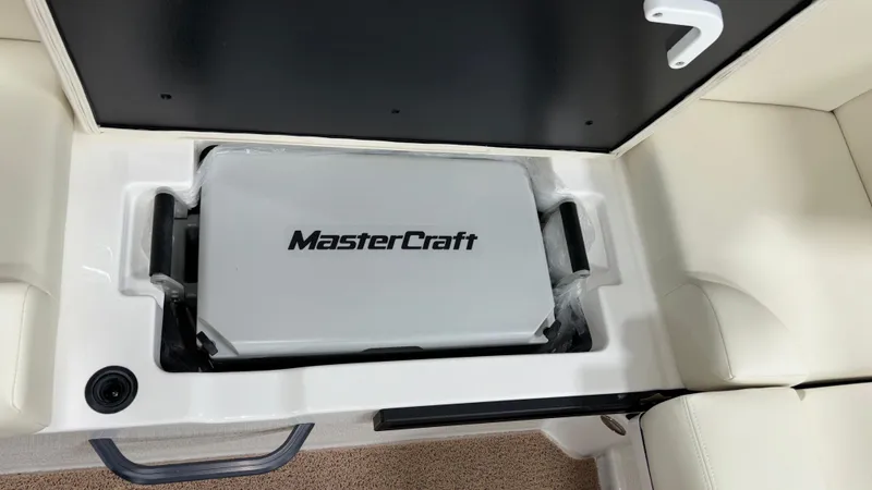 Slide: The Image of 2025 MasterCraft NXT23 boat storage compartment with branded cooler. - 36