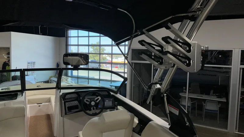 Slide: The Image of 2025 MasterCraft NXT23 boat interior with steering wheel and wakeboard rack. - 39