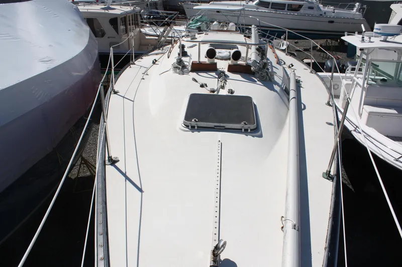 Slide: The Image of 1976 C&C 38 sailboat deck view, surrounded by other boats in a marina. - 10