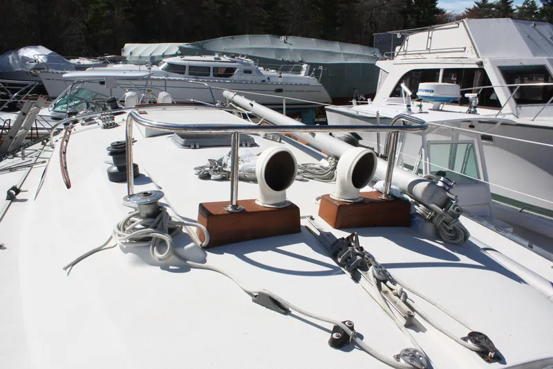 Slide: The Image of 1976 C&C 38 sailboat deck with rigging and moored yachts in background. - 12
